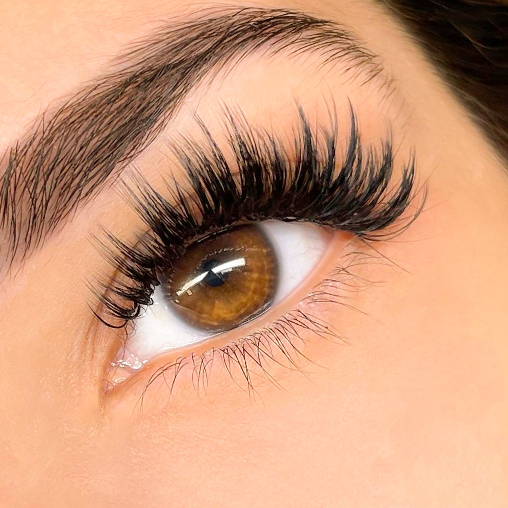 A close up of a woman 's eye with long eyelashes.