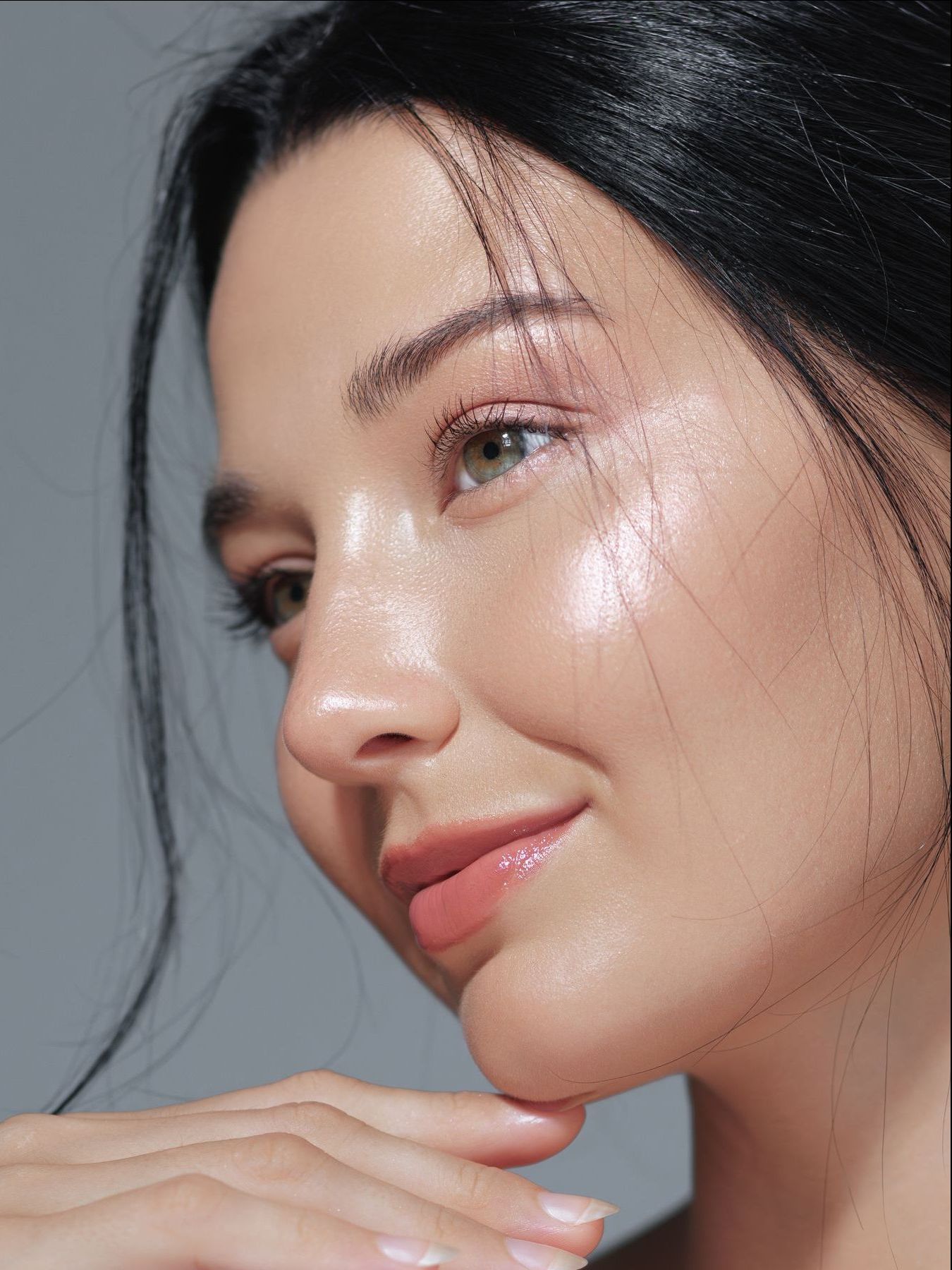 A woman with curly hair is smiling and looking over her shoulder.