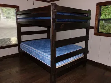 A bunk bed with a blue mattress in a room.