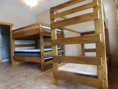 Two wooden bunk beds are sitting next to each other in a bedroom.