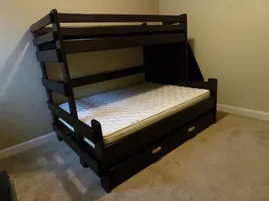 A bunk bed with a mattress underneath it in a bedroom.