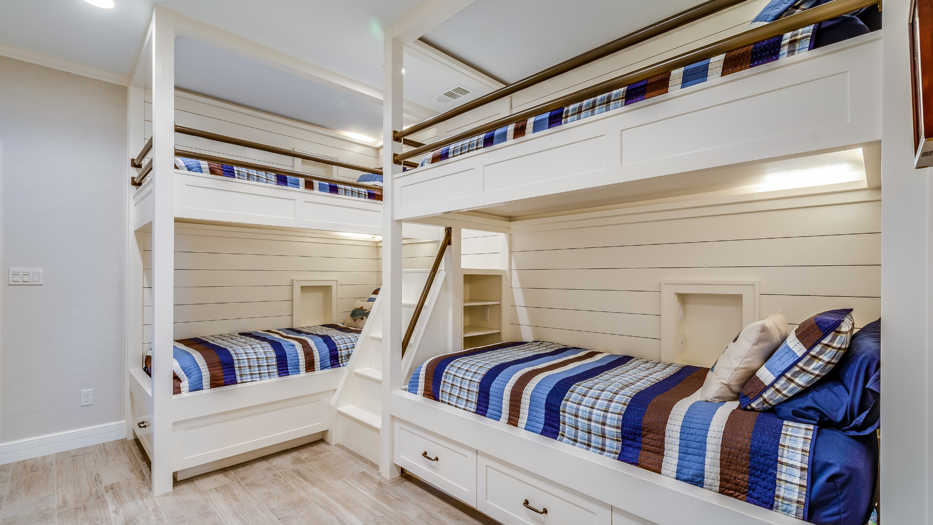A bunk bed with stairs leading up to it in a wooden room.