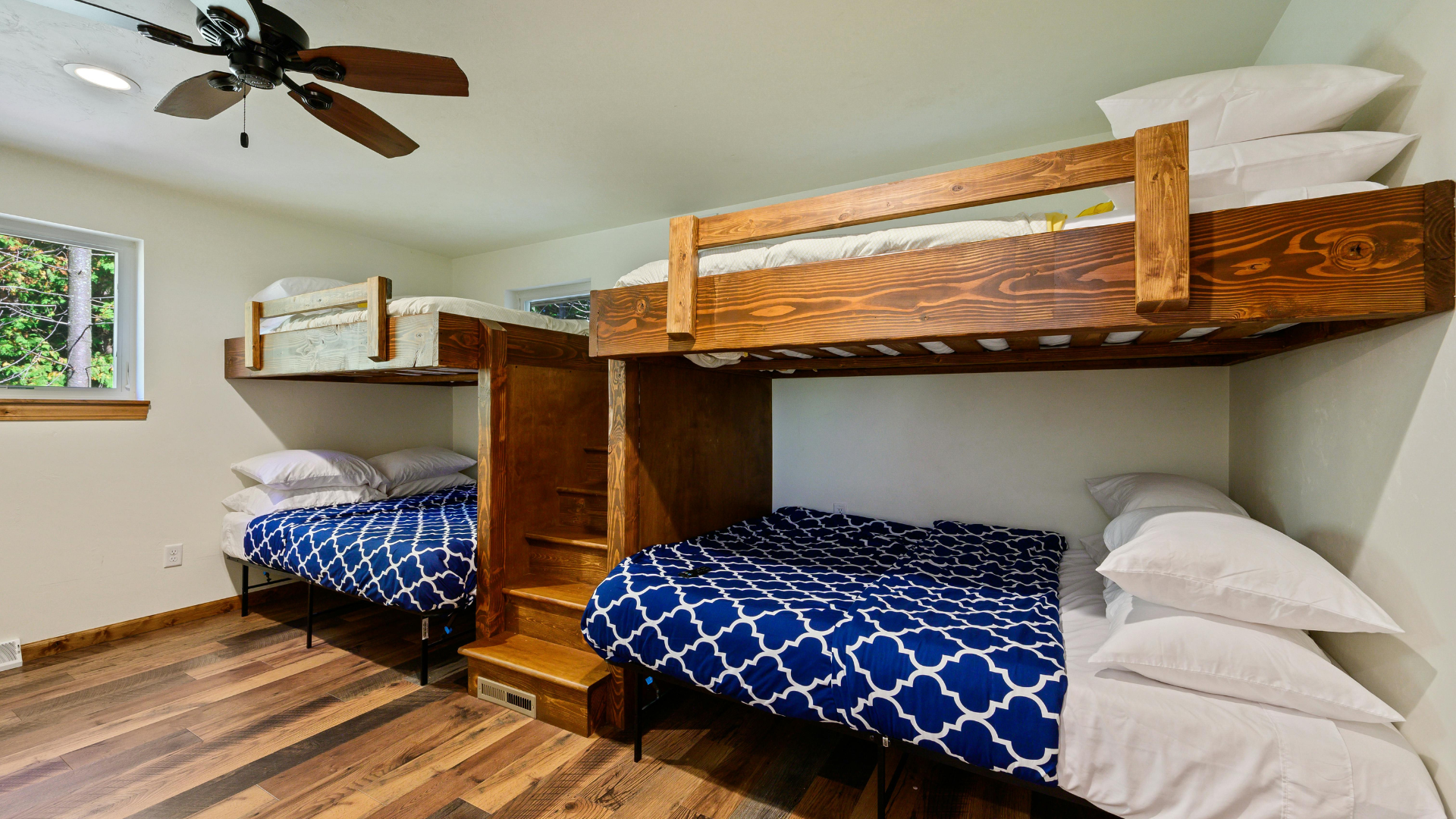 A bunk bed with stairs leading up to it in a wooden room.