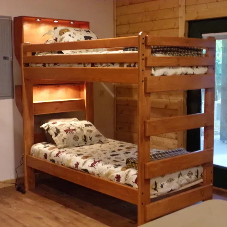A wooden bunk bed with a shelf above it