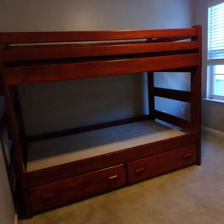 A bunk bed with drawers underneath it in a bedroom