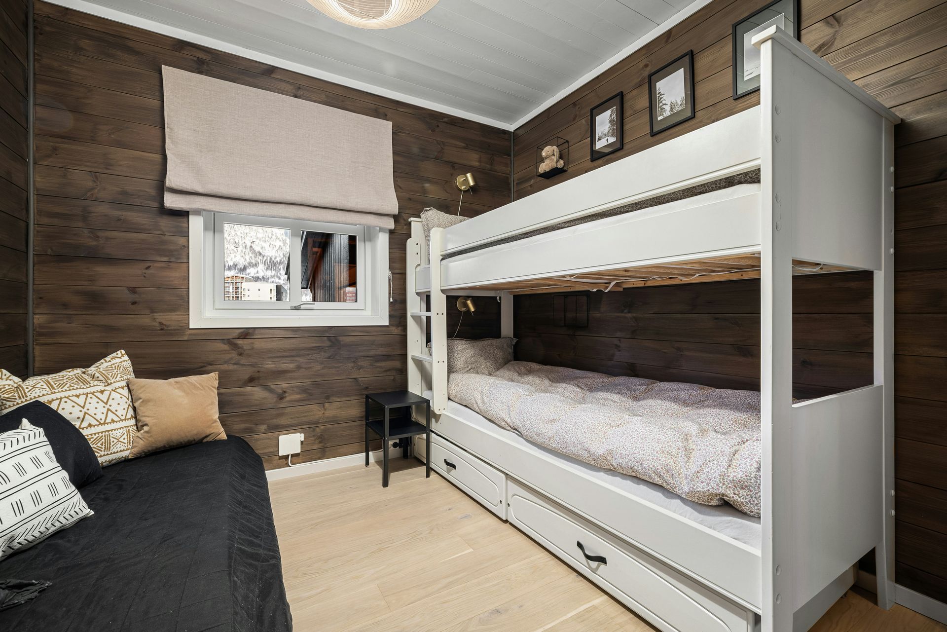 A bunk bed with stairs leading up to it in a wooden room.