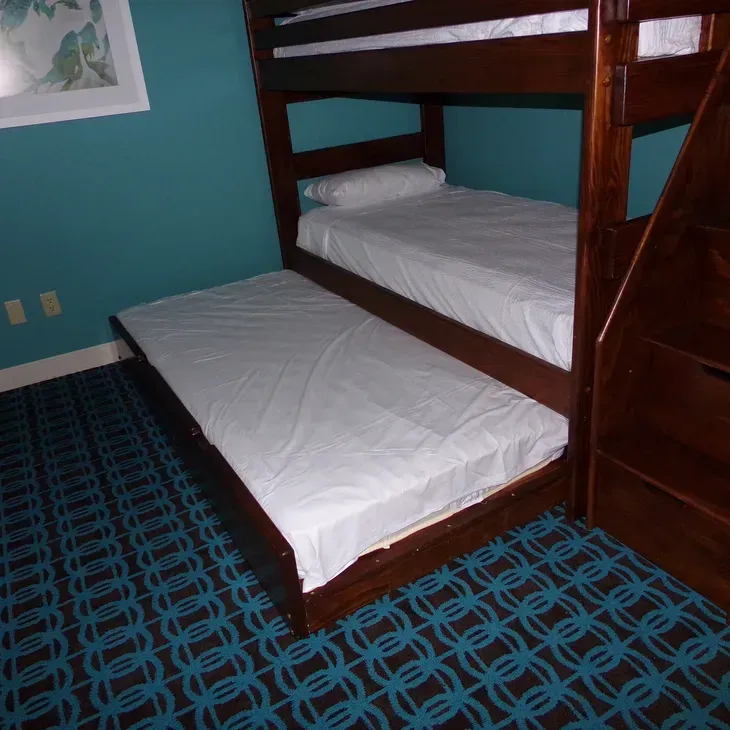 A bunk bed with a pull out bed underneath it