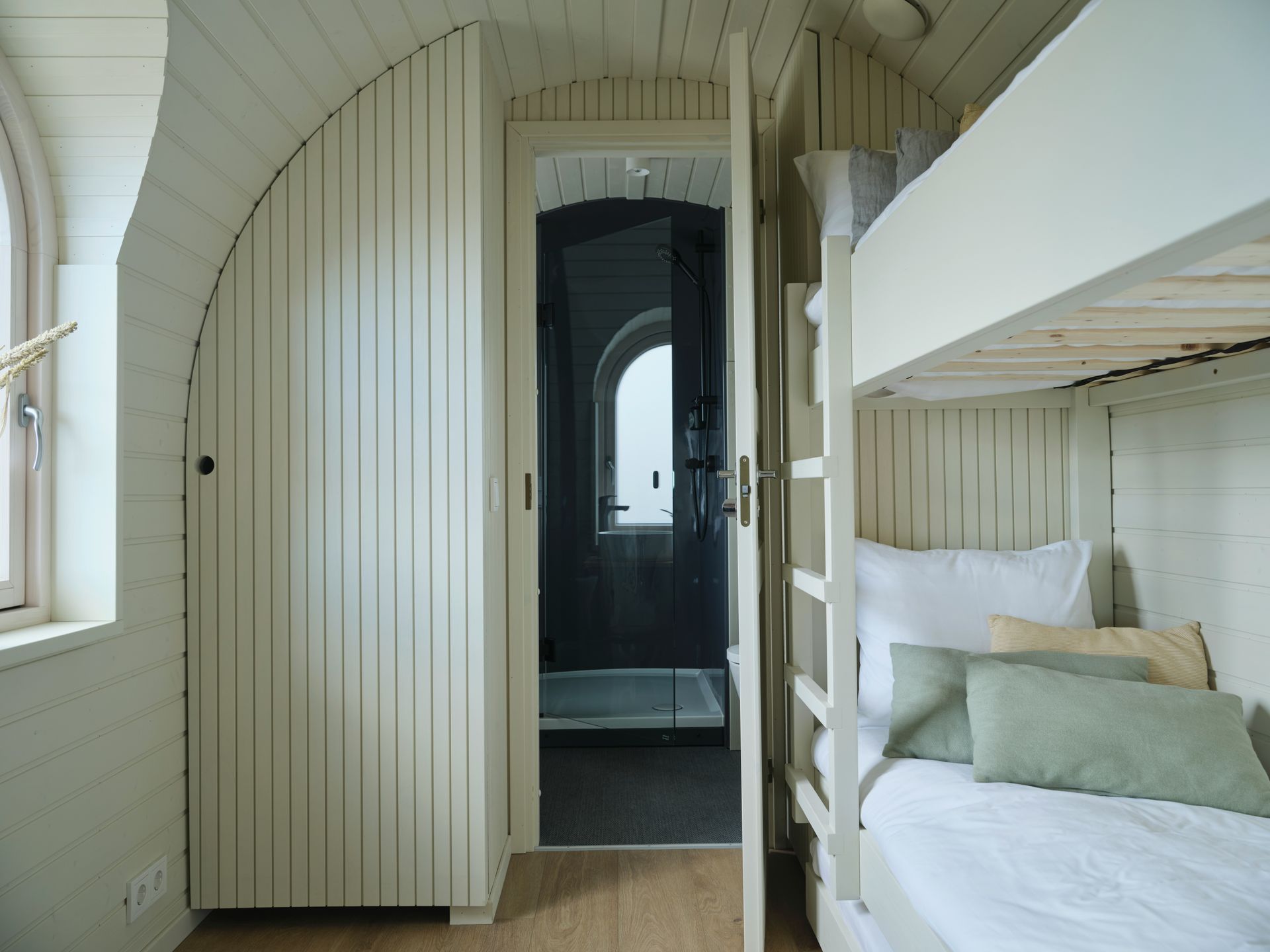 A bunk bed with stairs leading up to it in a wooden room.