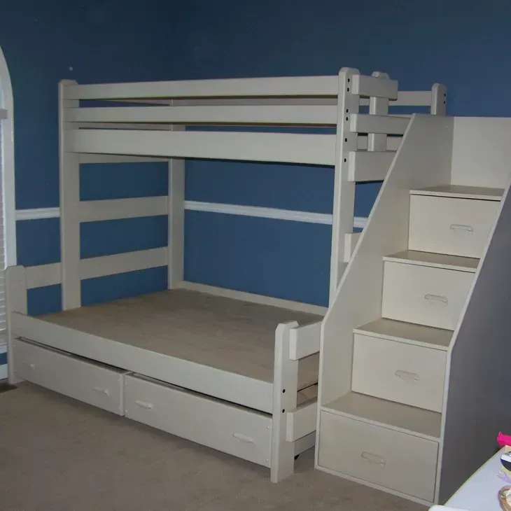 A bunk bed with stairs and drawers underneath it