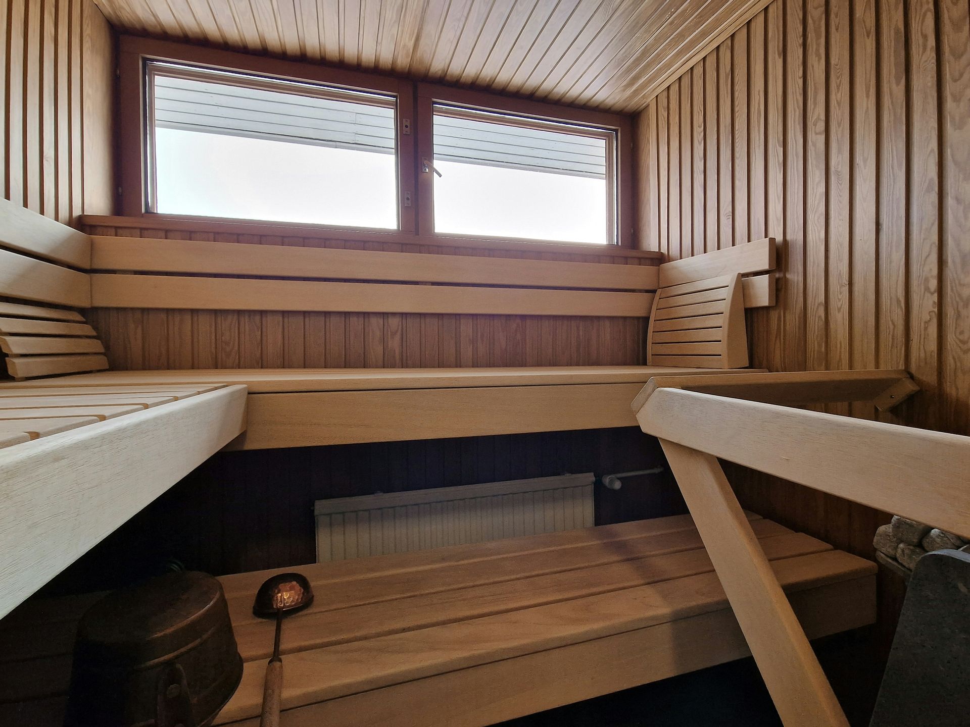 A bunk bed with stairs leading up to it in a wooden room.