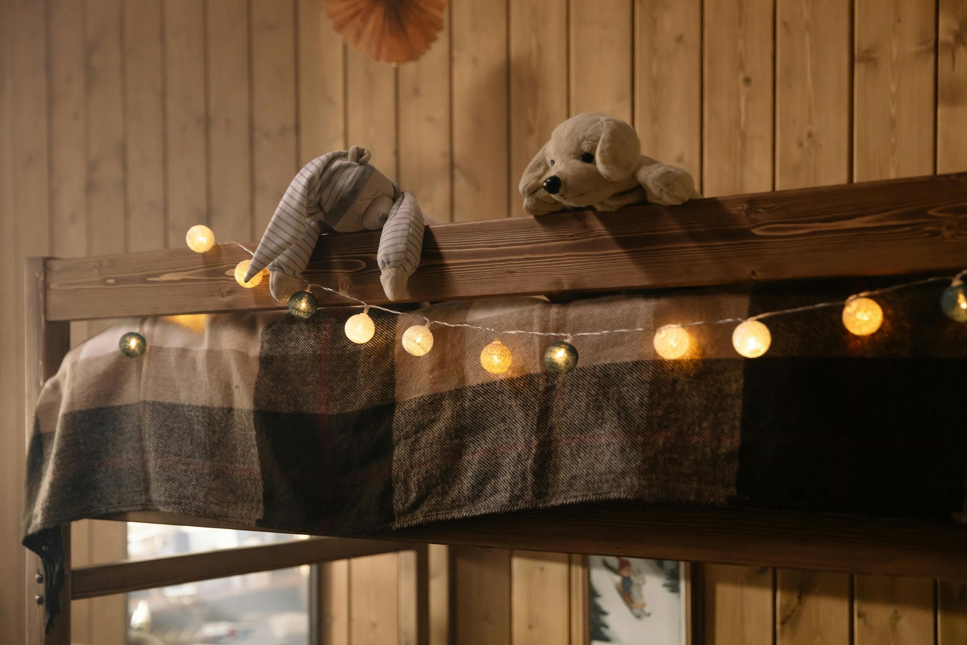 A bunk bed with stairs leading up to it in a wooden room.