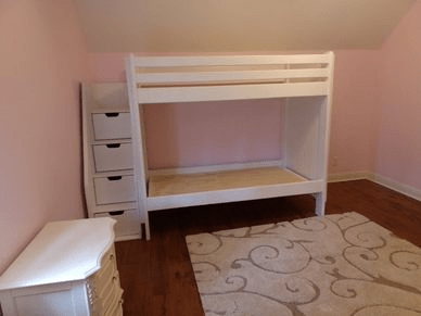 A bedroom with a bunk bed and a dresser