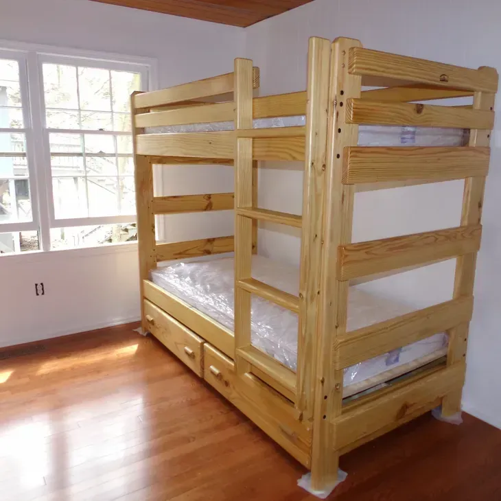 A wooden bunk bed in a room with a window