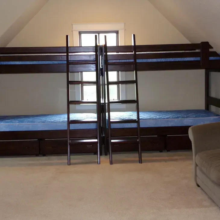 A room with two bunk beds and two stairs