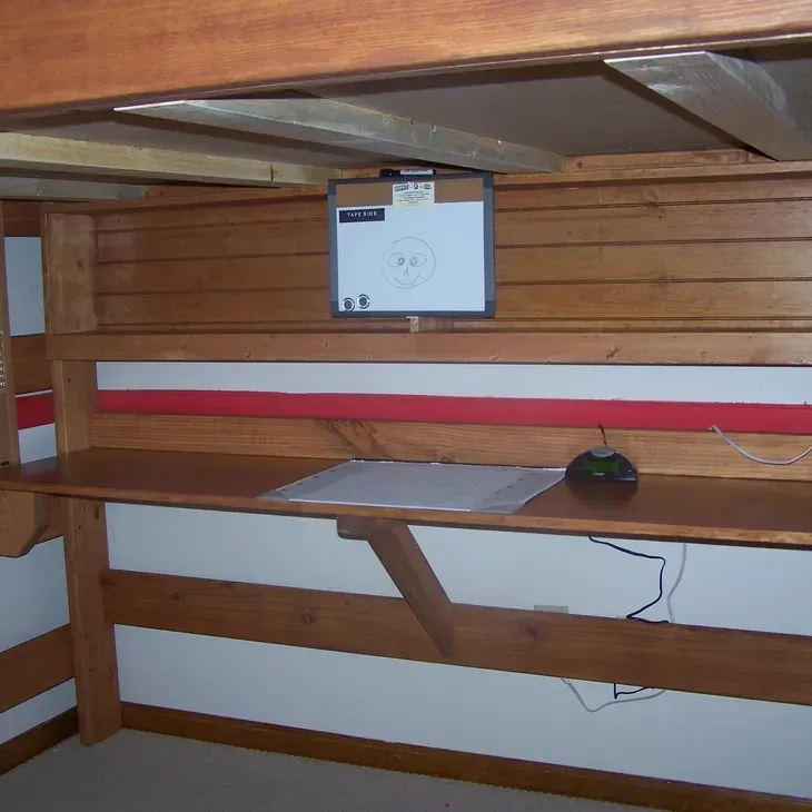 A wooden desk with a white board above it
