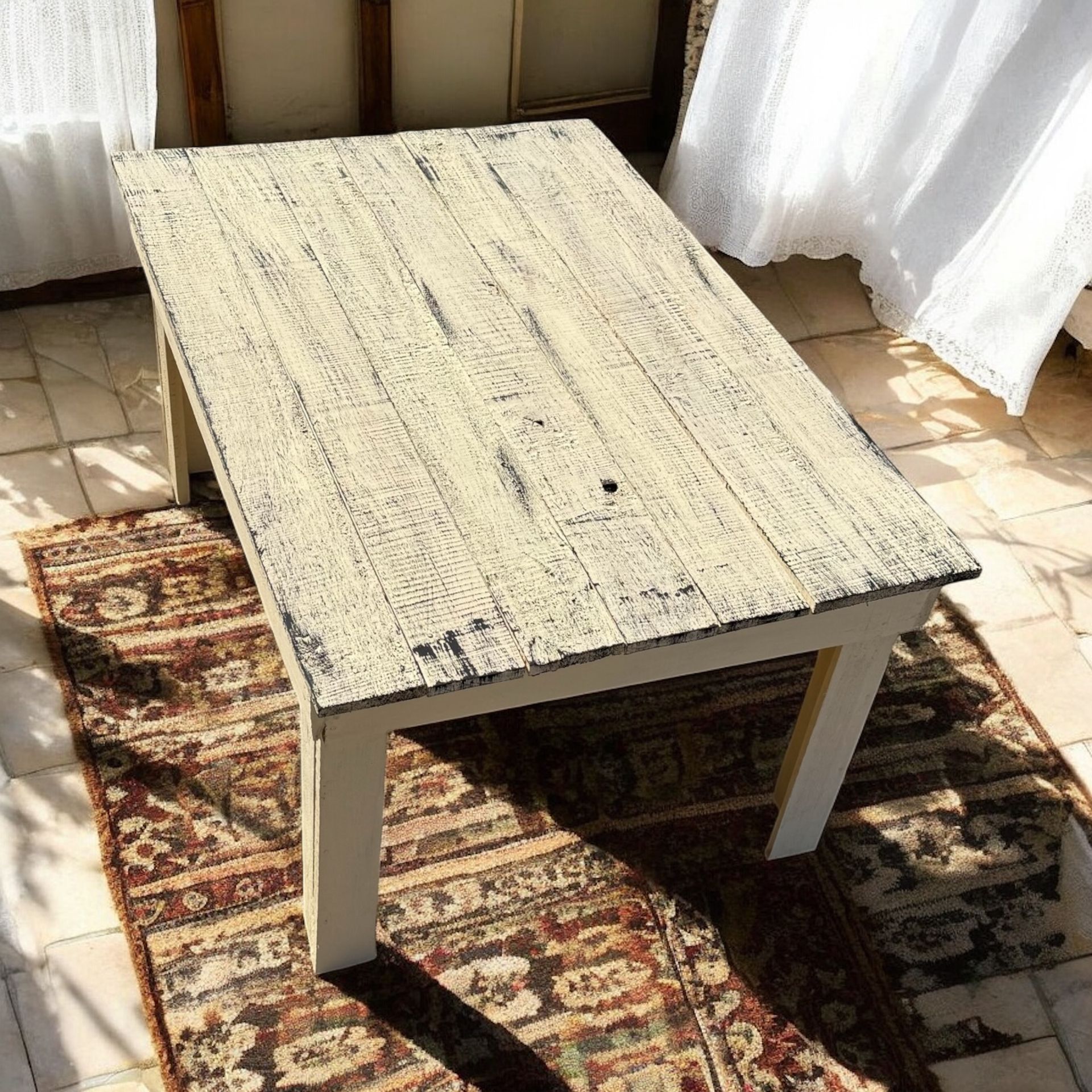 Una mesa de madera blanca está sobre una alfombra.