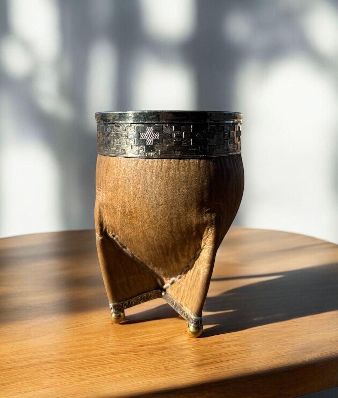Una taza de madera está sobre una mesa de madera.