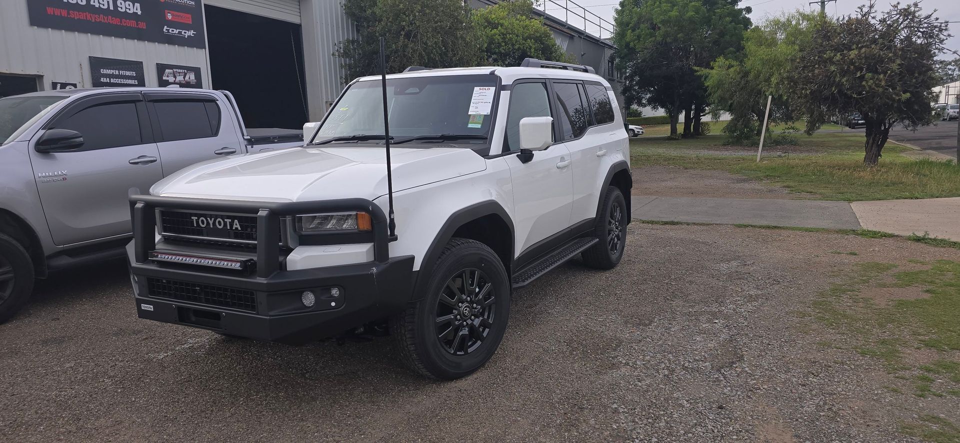 White Off-Road Vehicle Parked on Gravel. Black Grill Guard and Wheels — Sparky's 4x4 Auto Electrical In Taminda, NSW
