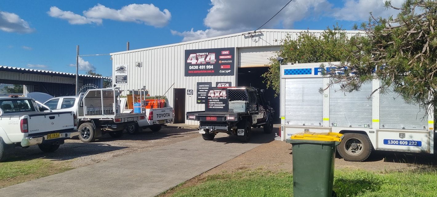 Exterior of A Workshop with Several Trucks Parked Outside, Sunny Day — Sparky's 4x4 Auto Electrical In Taminda, NSW