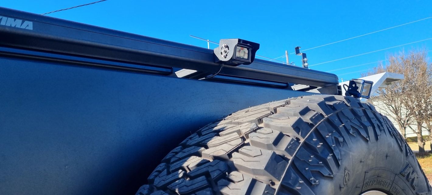 Black Vehicle with A Spare Tire, Rack with A Light, Against a Clear Blue Sky — Sparky's 4x4 Auto Electrical In Armidale, NSW