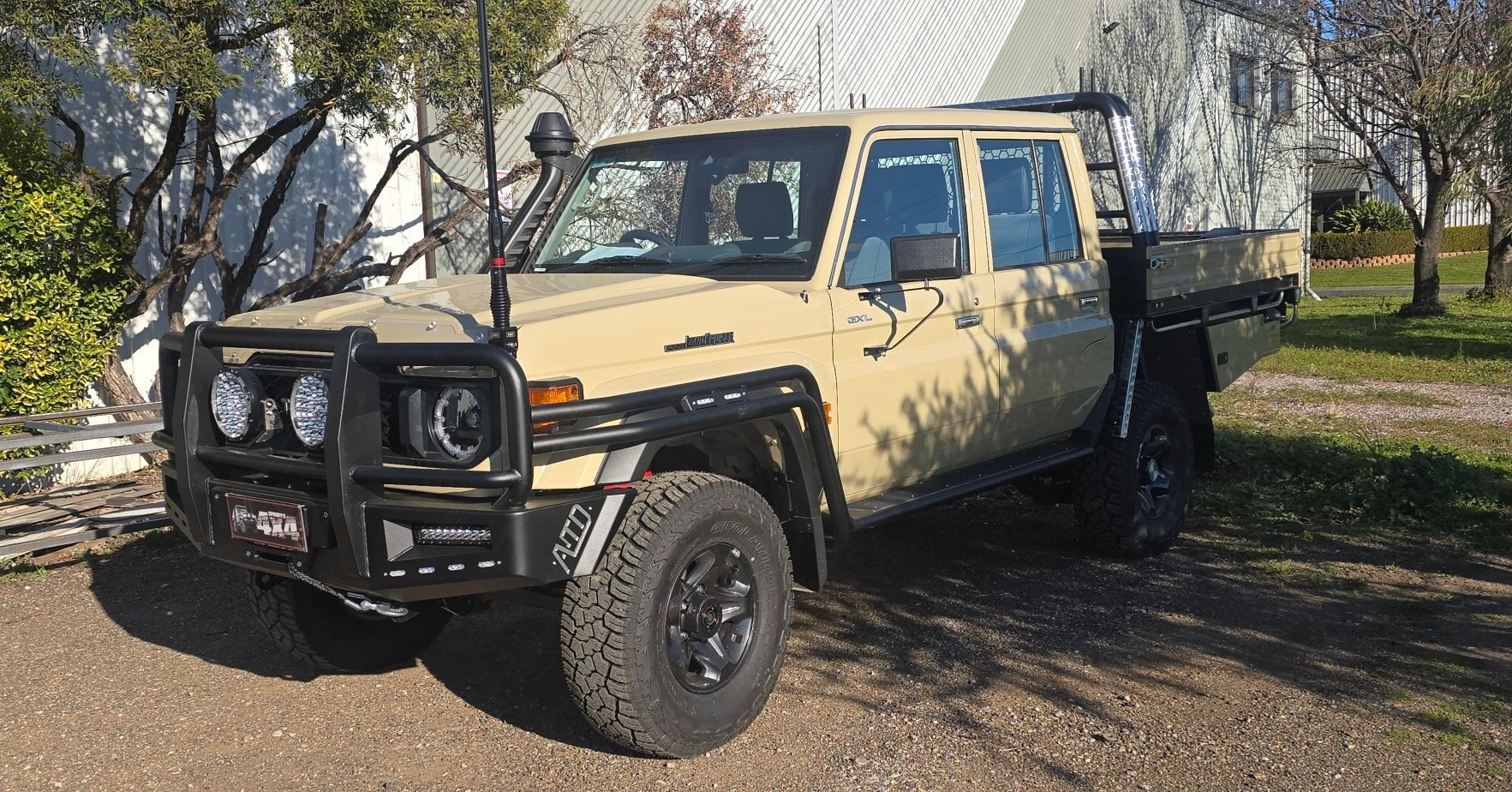 Tan Toyota Land Cruiser with Bull Bar and Black Wheels Parked on Driveway — Sparky's 4x4 Auto Electrical In Taminda, NSW