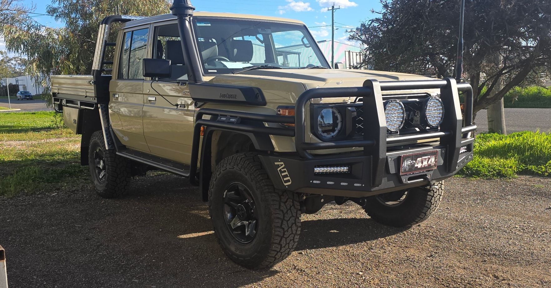 Tan Toyota Land Cruiser Pickup Truck with Black Bull Bar and Off-Road Tires — Sparky's 4x4 Auto Electrical In Taminda, NSW