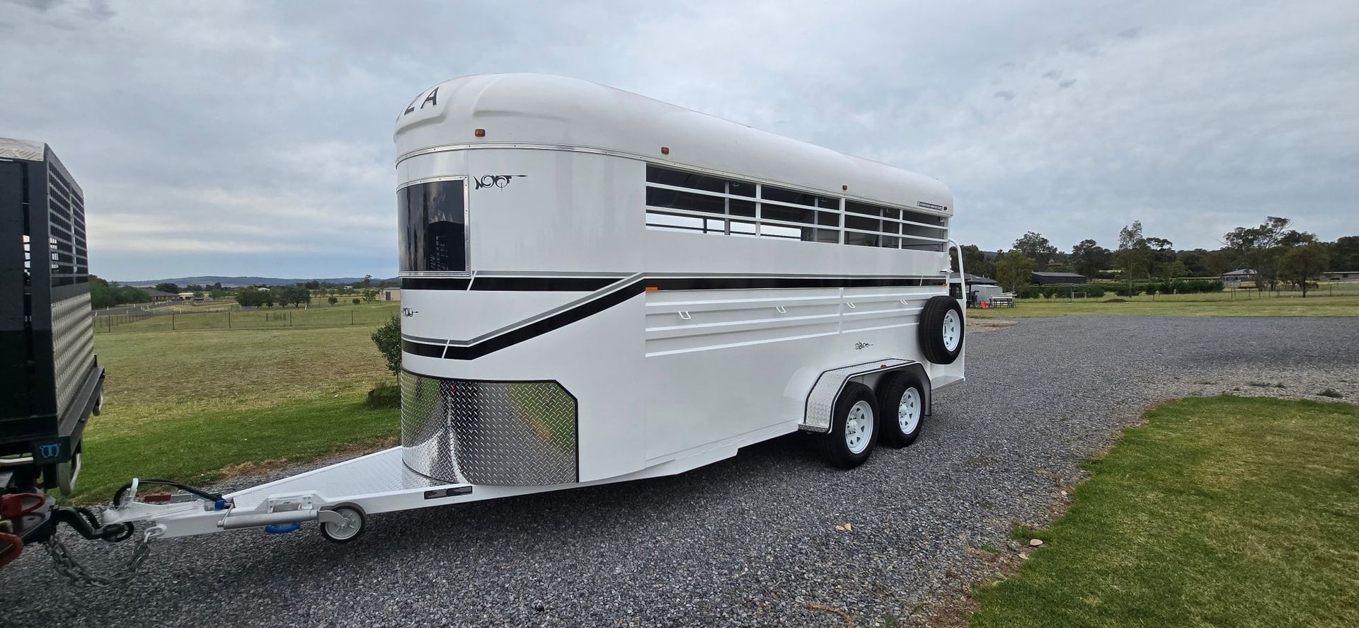 White Horse Trailer Parked on Gravel, Under a Cloudy Sky — Sparky's 4x4 Auto Electrical In Taminda, NSW