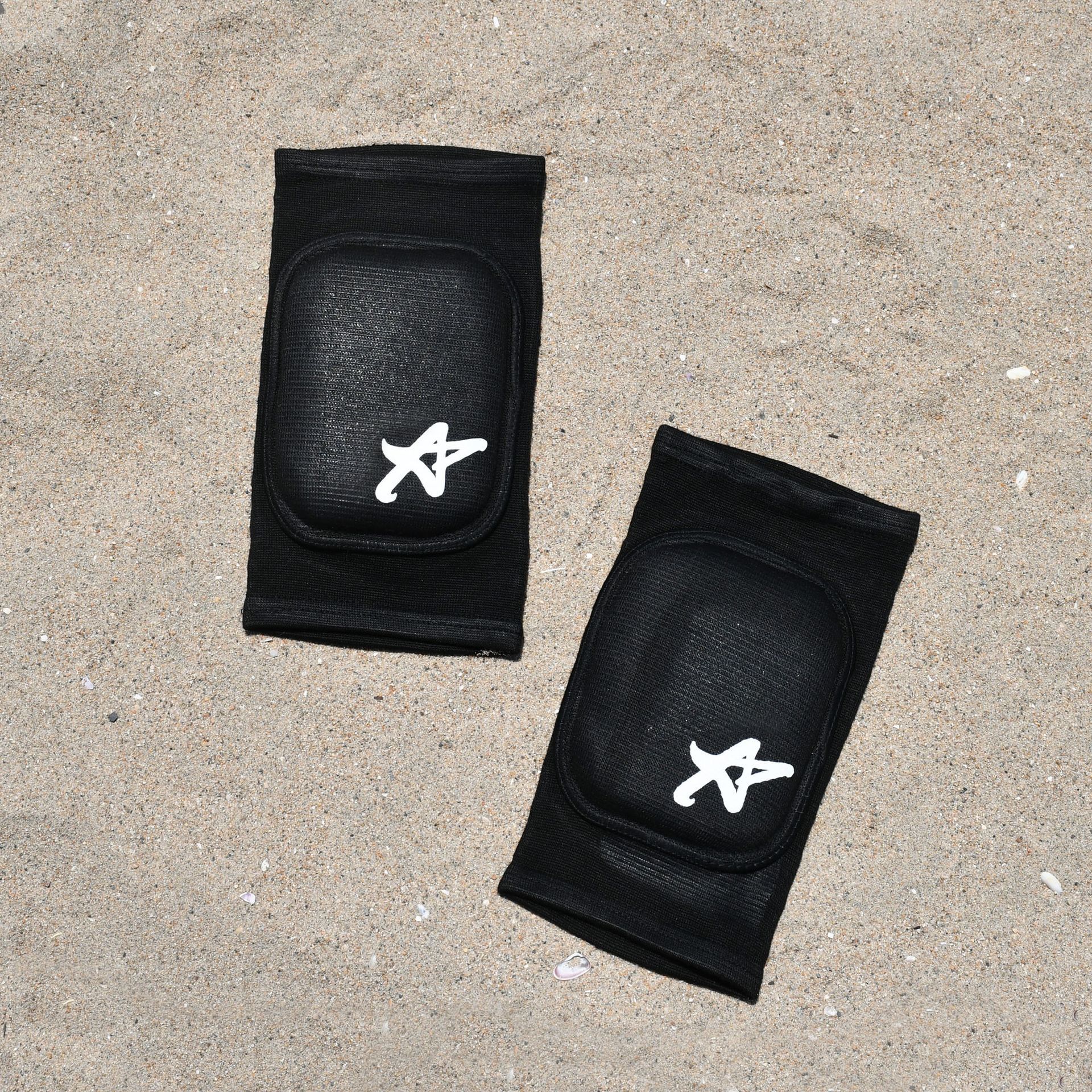 A pair of black knee pads with the letter a on them