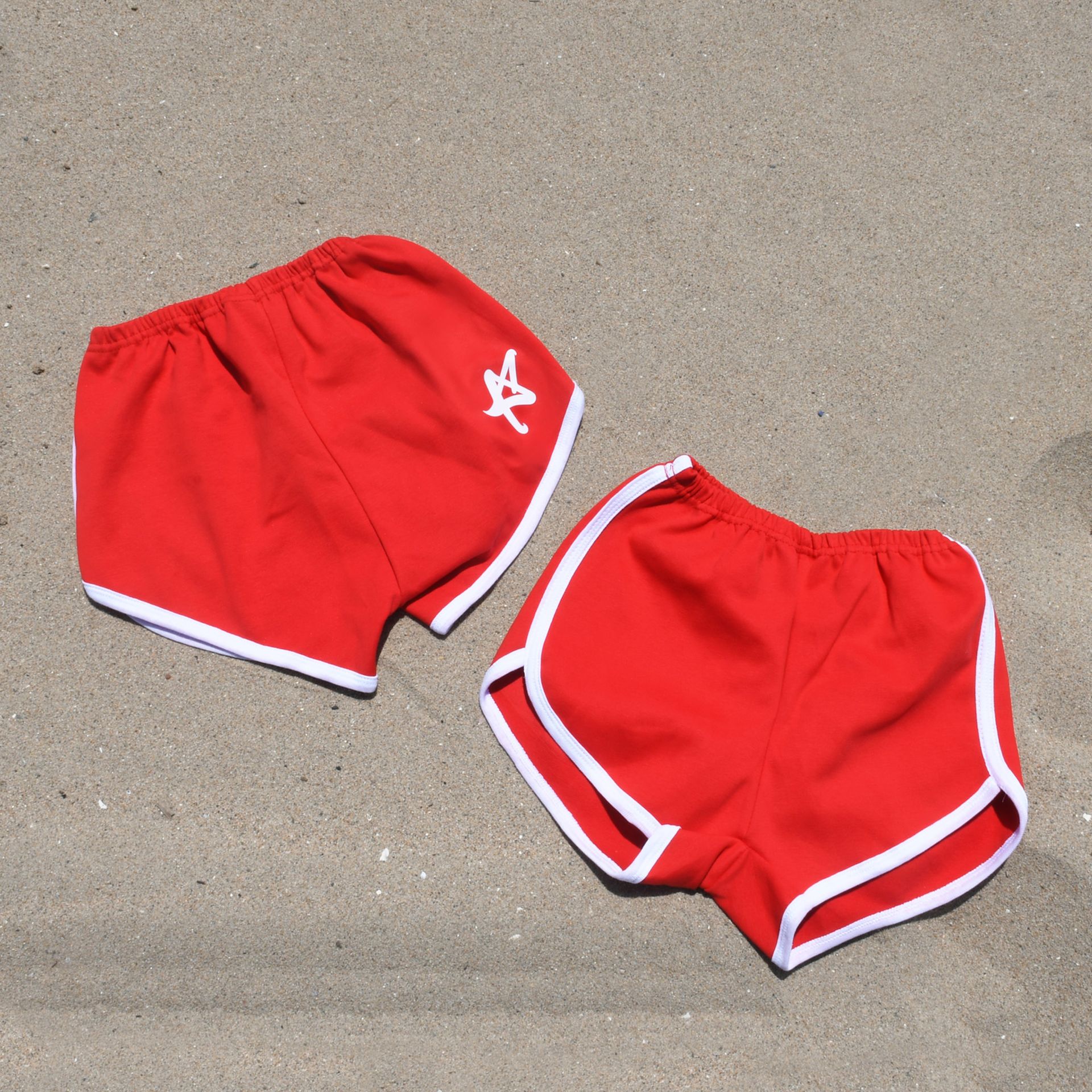 A pair of red shorts with a white star on the side