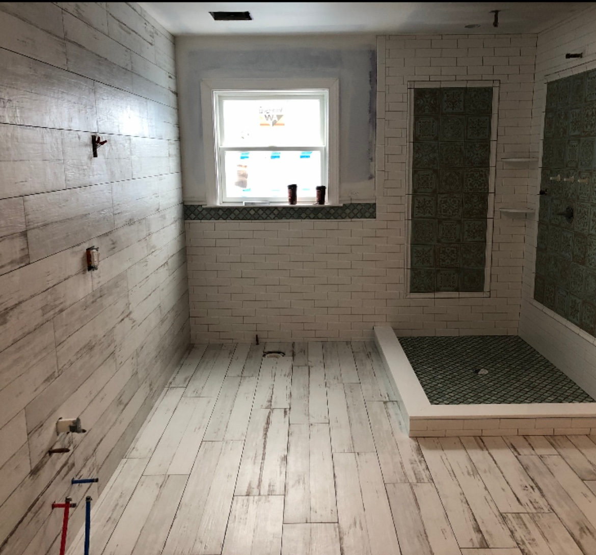 A bathroom with white tiles and a walk in shower