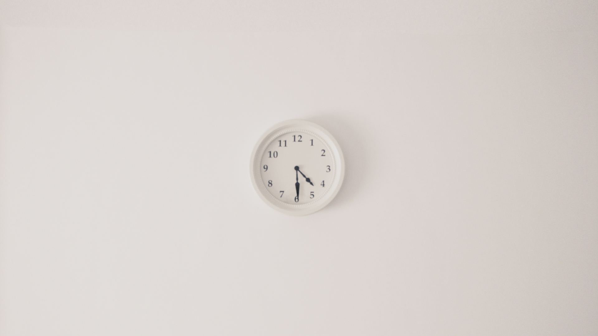 A clock on a blank white wall