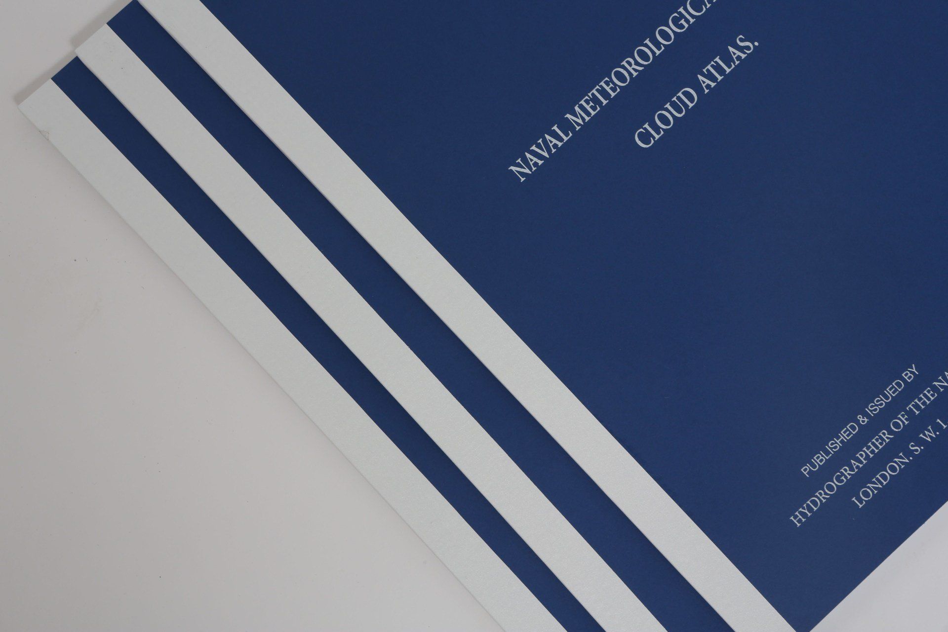 A blue and white book titled naval meteorological cloud atlas