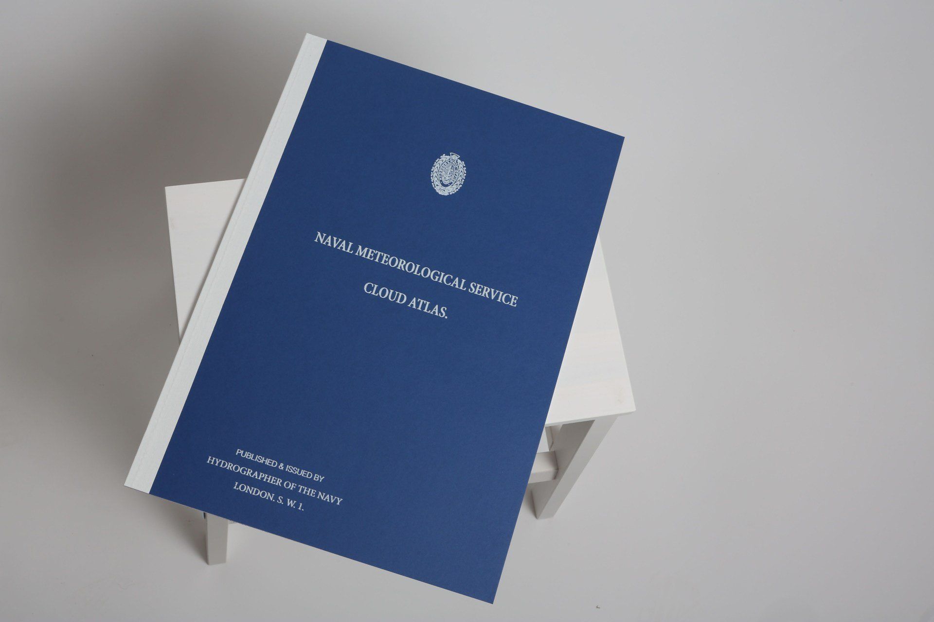 A blue book is sitting on top of a white table.