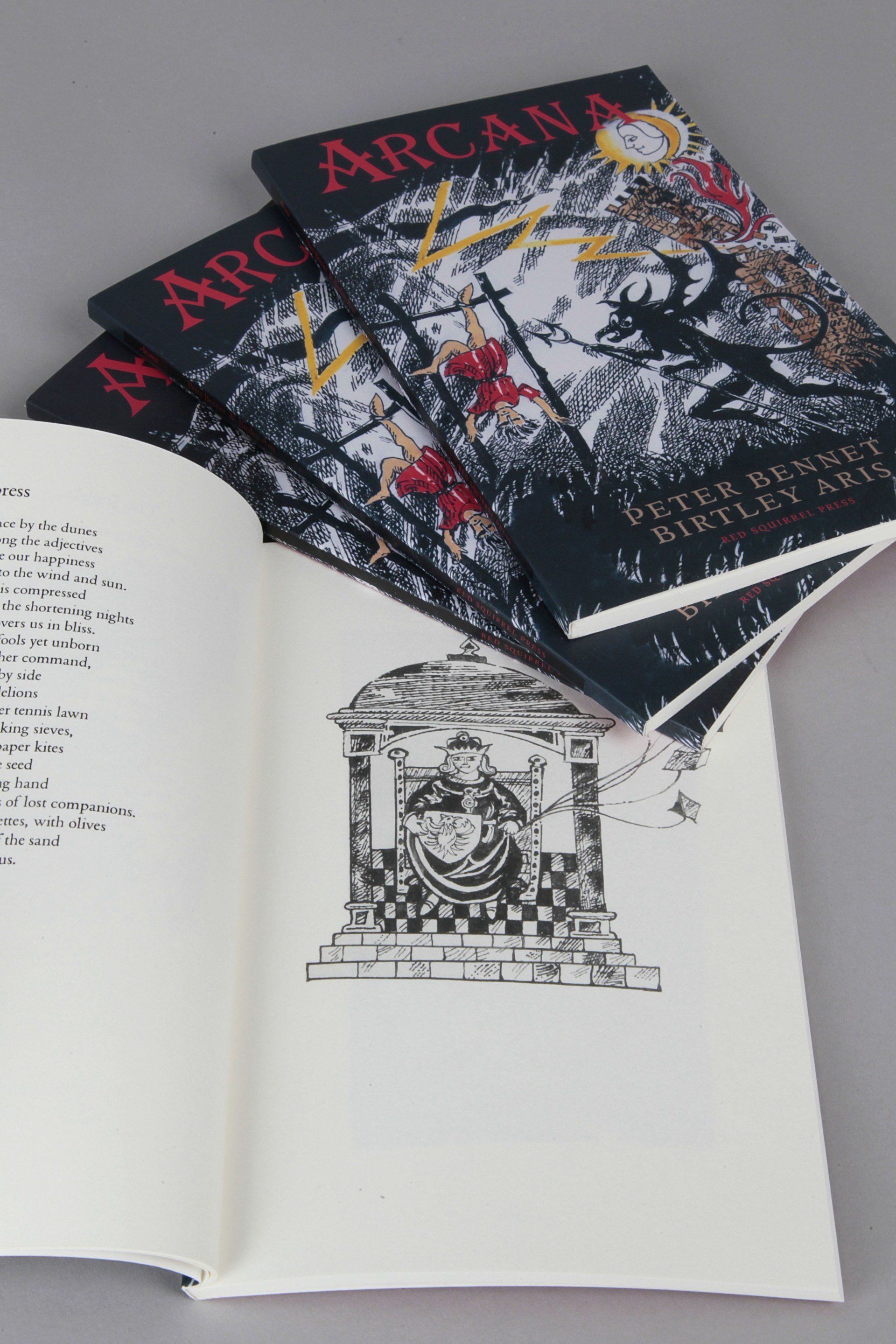 A book called arcana is stacked on top of each other