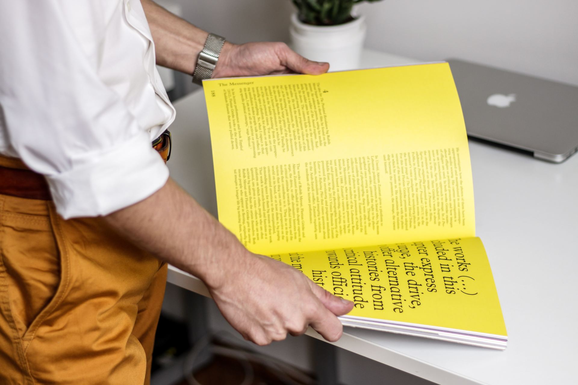 Man opening magazine at double spread page filled with type
