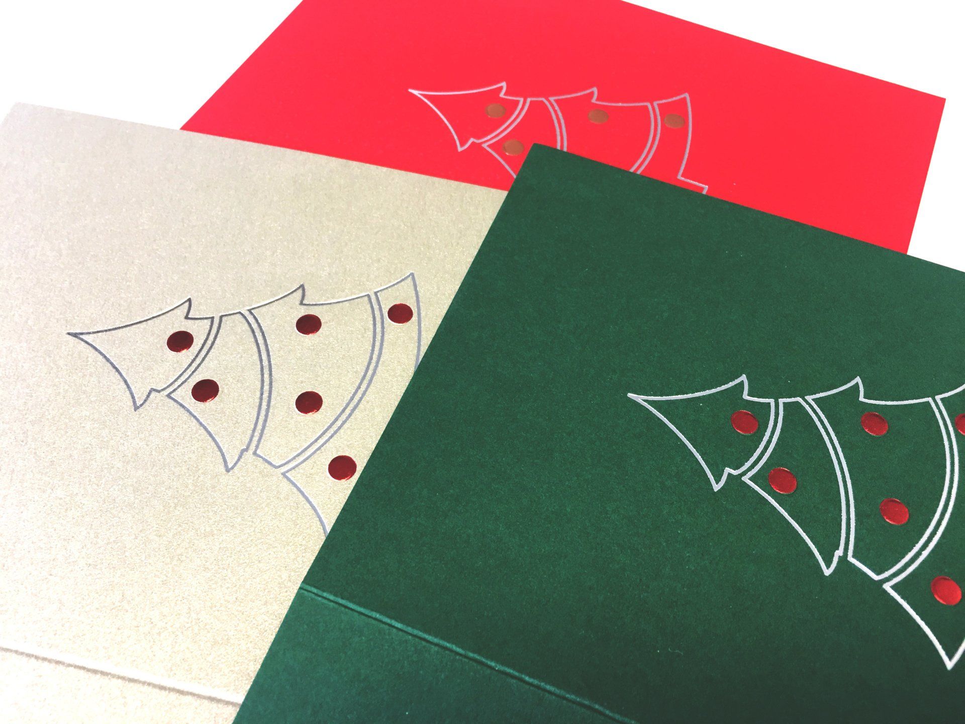 Green, red and cream coloured Christmas card with a silver foil outline of a tree and red baubles