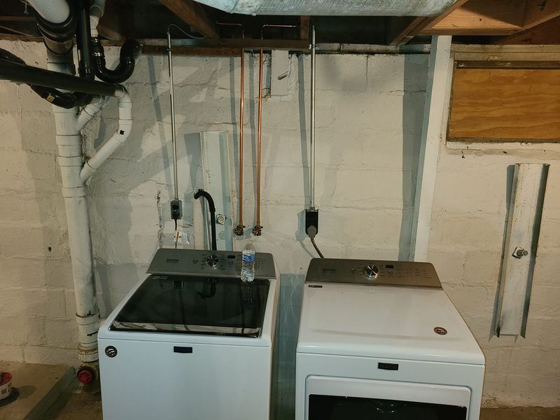 A washer and dryer are sitting next to each other in a basement.