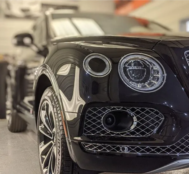 A black bentley is parked in a garage