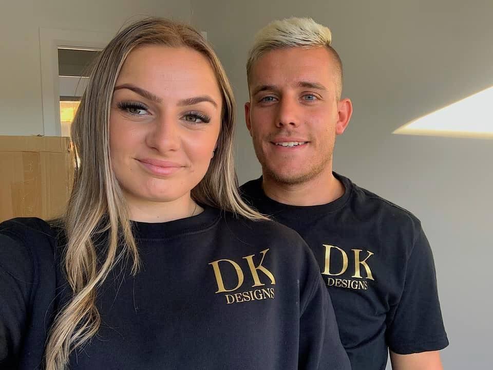 A woman and a man in matching black shirts with