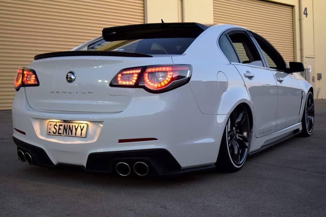 White sedan with black accents, lowered suspension, and custom rear. White sedan with black accents, lowered suspension, and custom rear.
