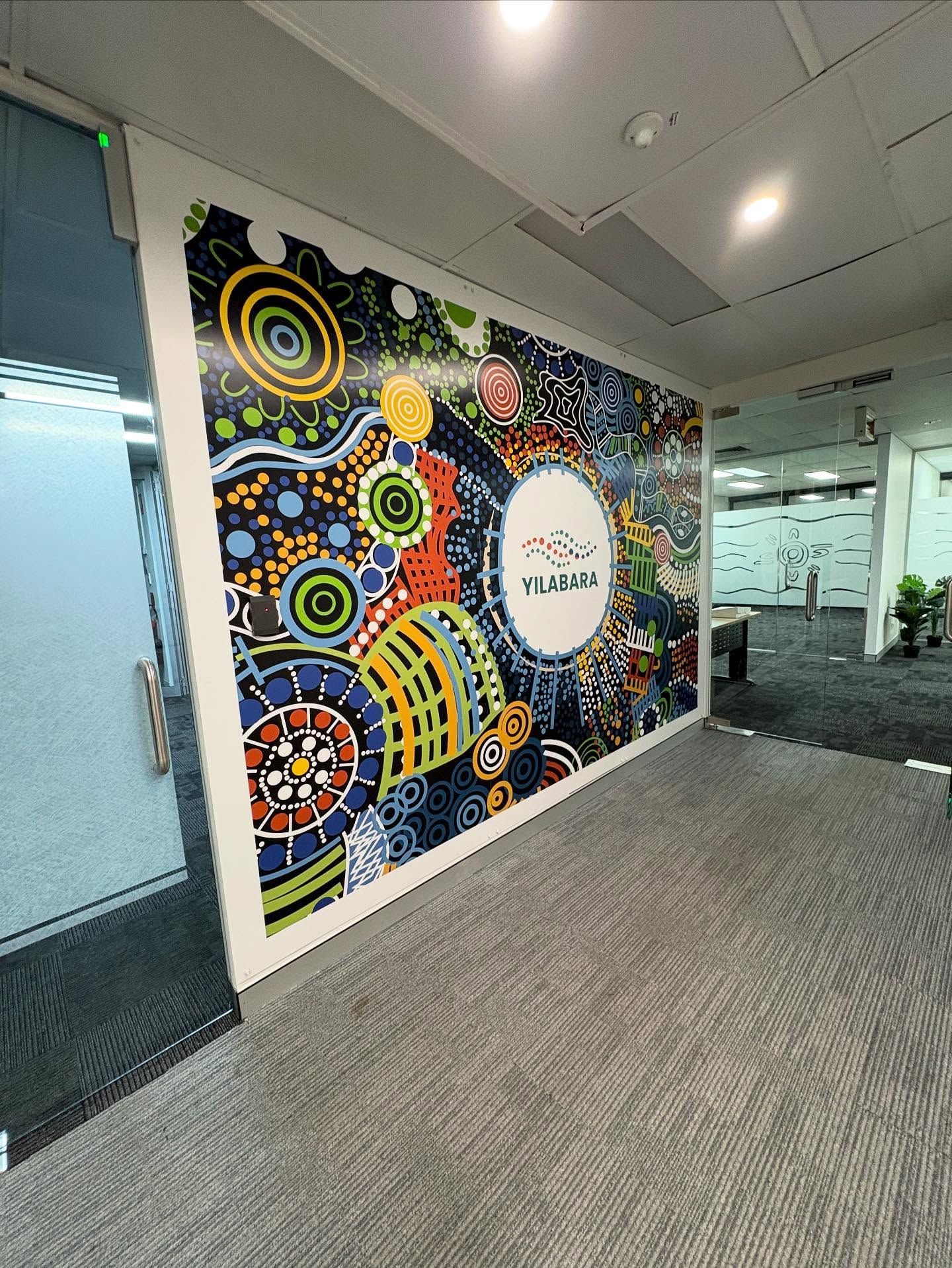 Aboriginal art mural on office wall, colorful circles and dots, 