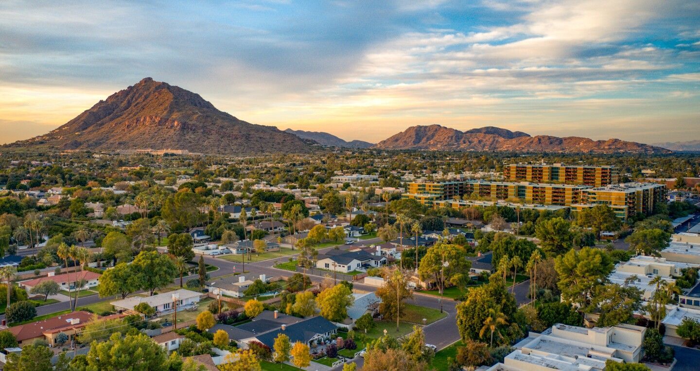 An aerial view of a residential area with a mountain in the background.