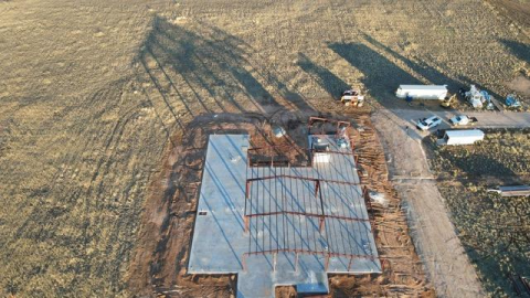 A large metal building is being built in a garage