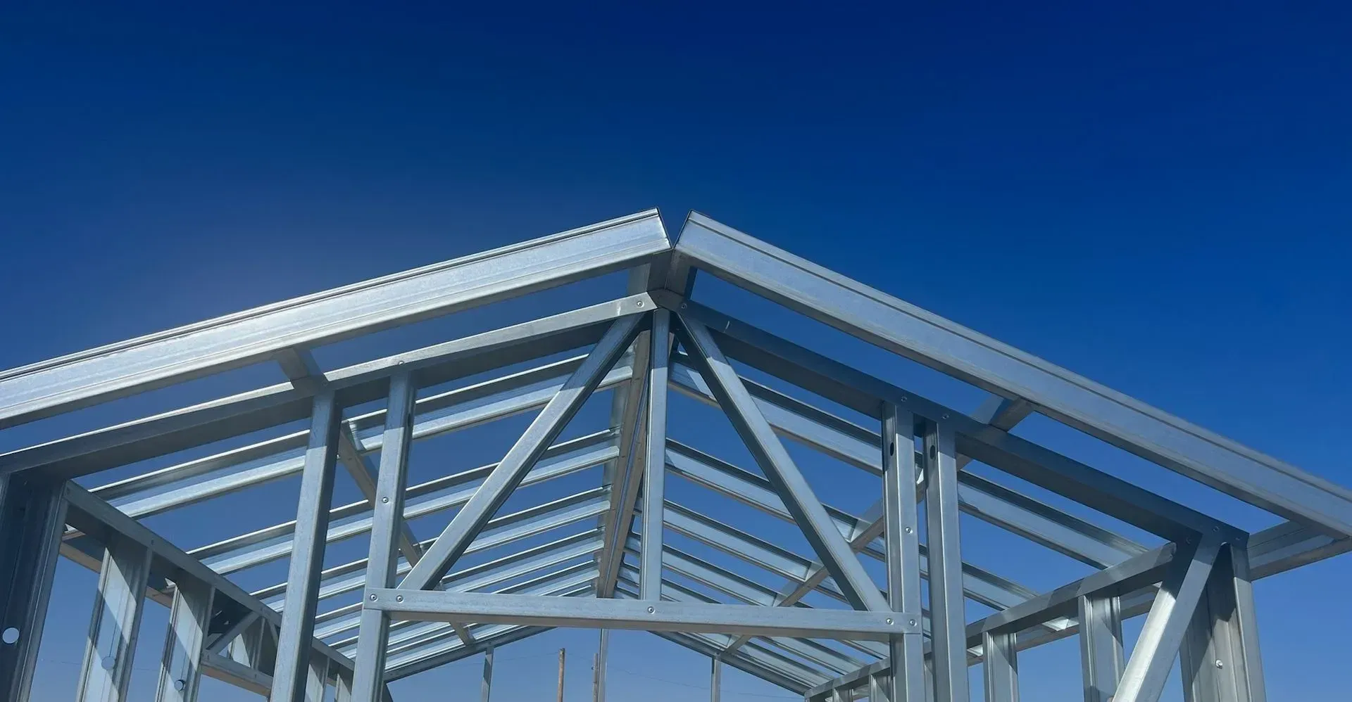 A metal structure is being built with a blue sky in the background.
