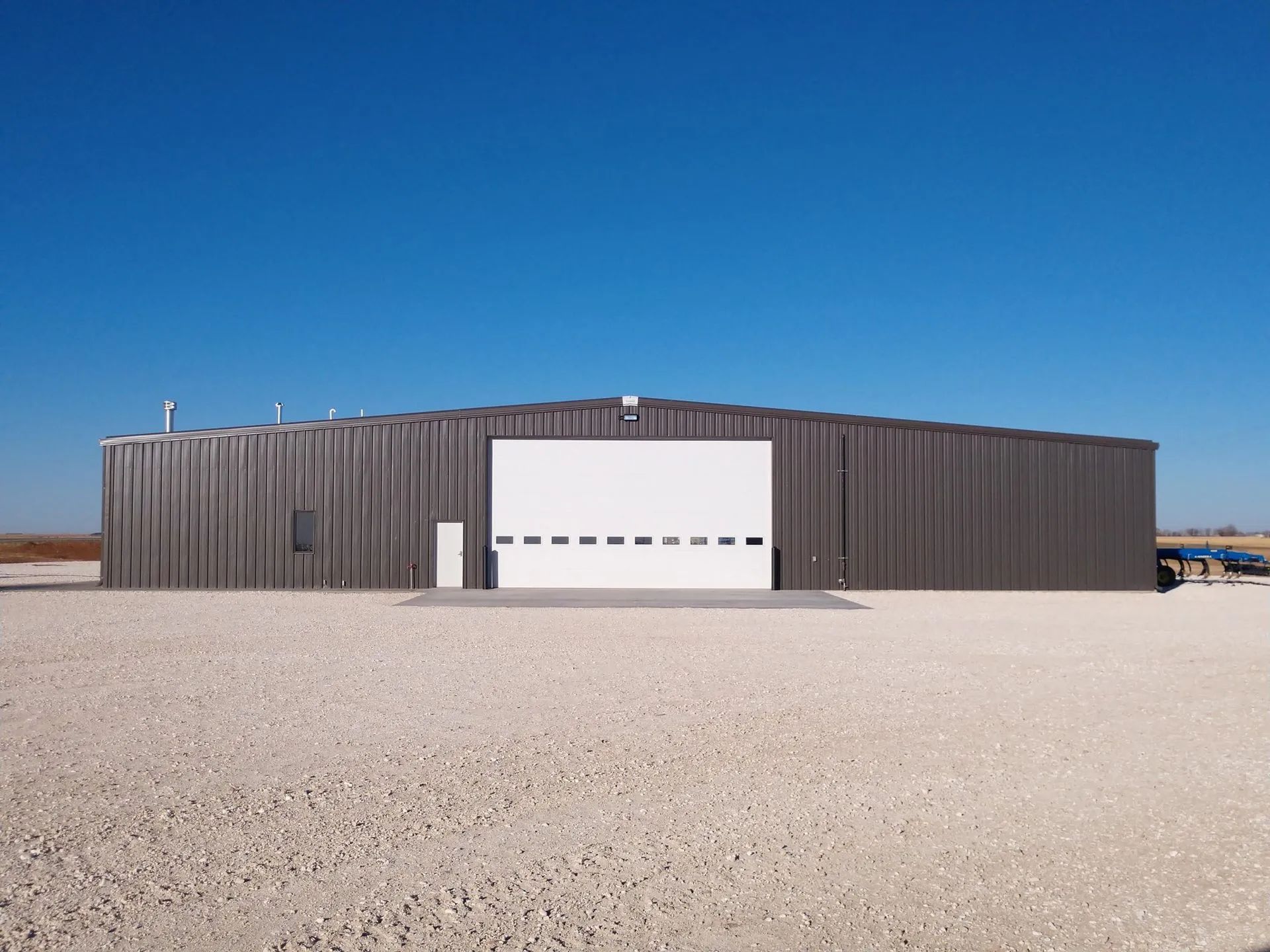 A large metal building with a white garage door