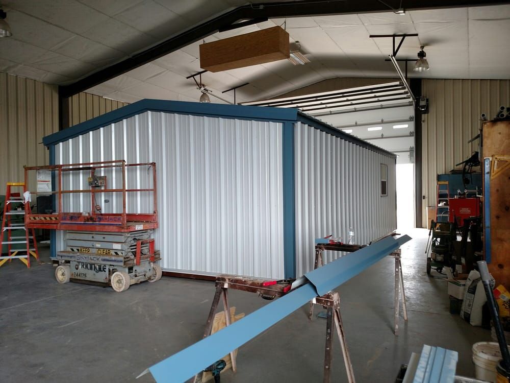 A large metal building is being built in a garage