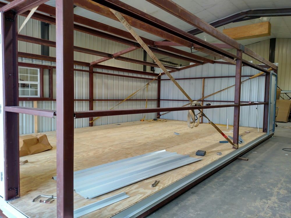 A large metal structure is being built in a warehouse.