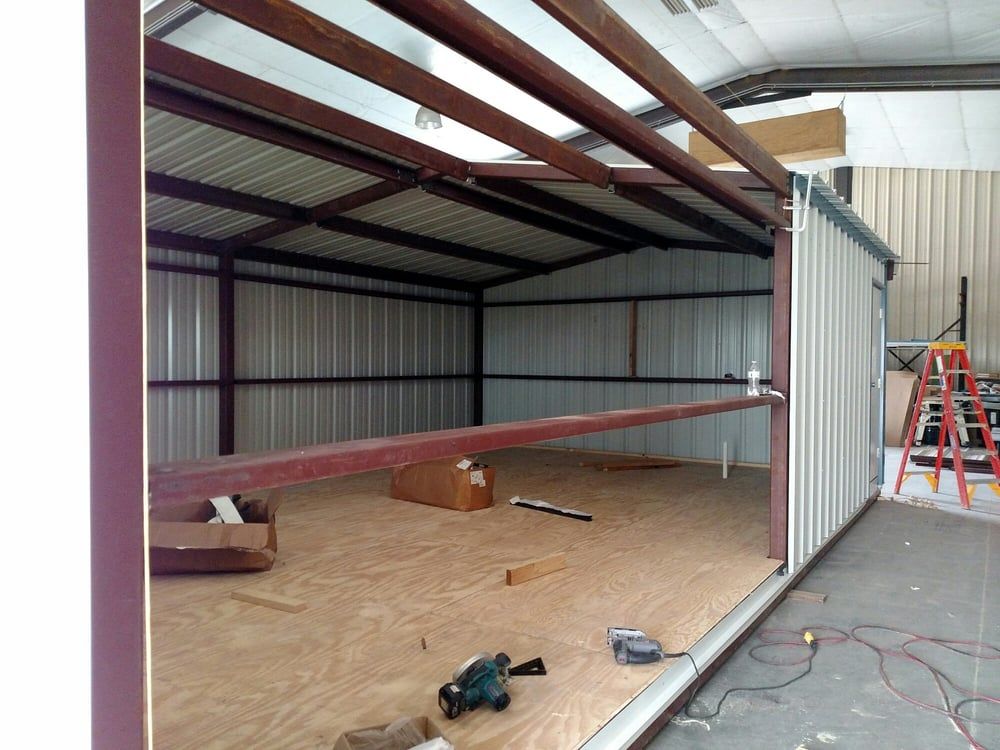 The inside of a metal building with a ladder in the background