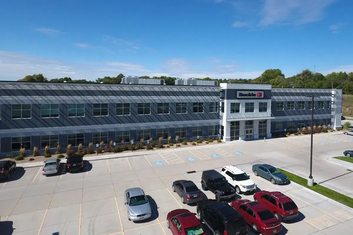 An aerial view of a large building with cars parked in front of it.