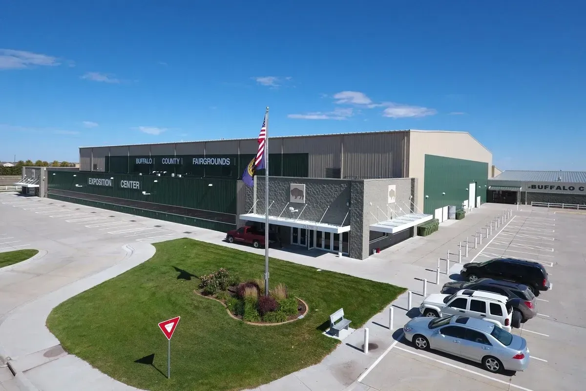 An aerial view of a large building with cars parked in front of it.